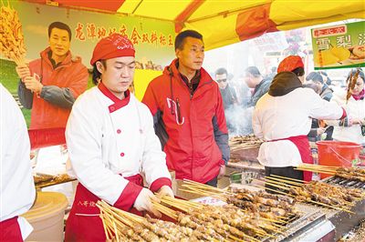 賣羊肉串?dāng)偽焕习遐w山（穿紅衣者）。新京報(bào)記者