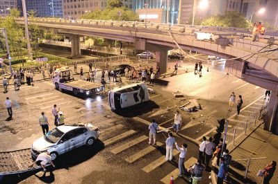 路虎沖下國貿橋砸中一輛起亞轎車，橋上厚達幾十厘米的水泥護欄被撞斷，碎石四處散落，數(shù)十群眾在現(xiàn)場圍觀。