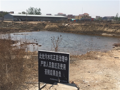 化肥廠滲坑的三分之一經(jīng)過治理，但水質(zhì)仍然呈黃褐色。
