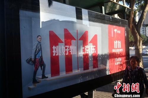 資料圖：11月1日，福州民眾從雙十一廣告牌前經(jīng)過。中新社記者 呂明 攝