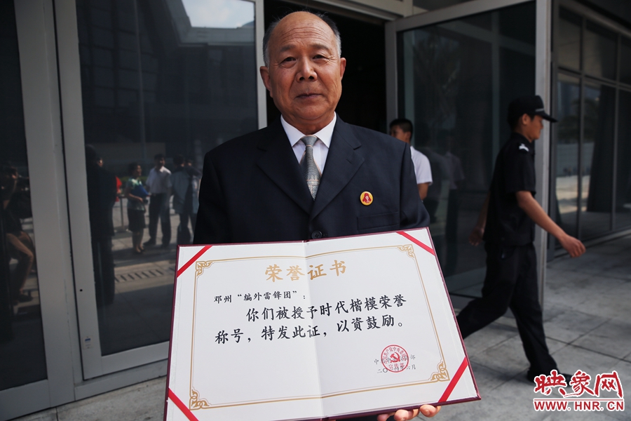 河南鄧州“編外雷鋒團(tuán)”團(tuán)長(zhǎng)宋清梅向眾多記者展示中宣部授予的“時(shí)代楷?！睒s譽(yù)證書(shū)。