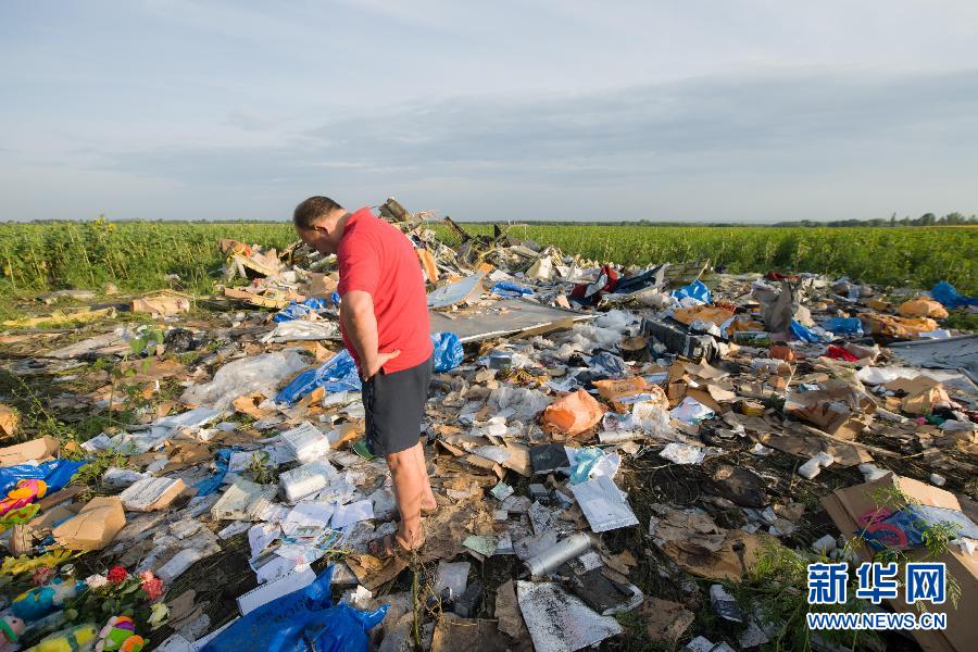 　7月19日,在烏克蘭頓涅茨克州,一名當?shù)孛癖娬驹隈R航MH17航班墜機現(xiàn)場。