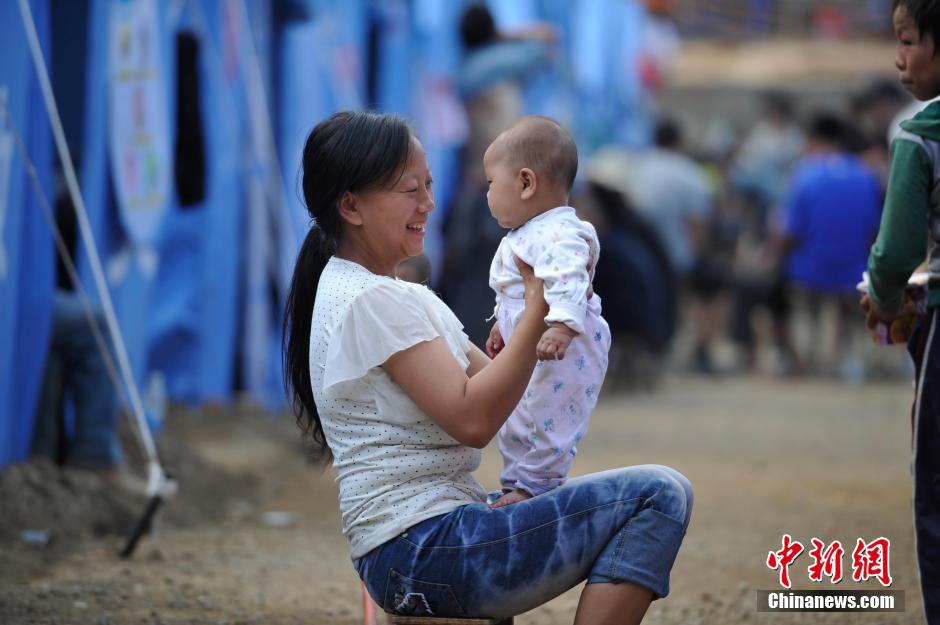 8月6日，一名年輕的母親在和孩子玩樂。