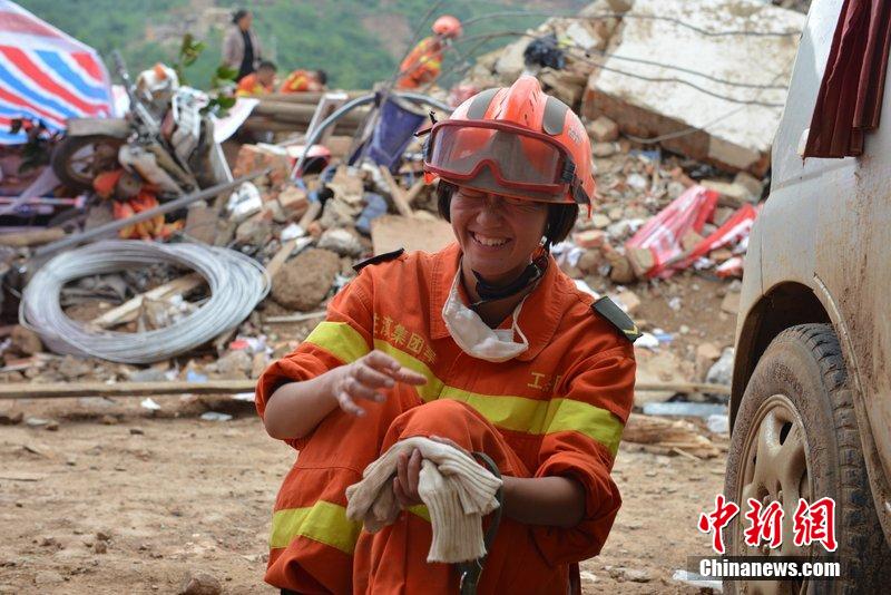 2014年8月5日，女兵在云南魯?shù)辇堫^山鎮(zhèn)廢墟中搜救被困者。