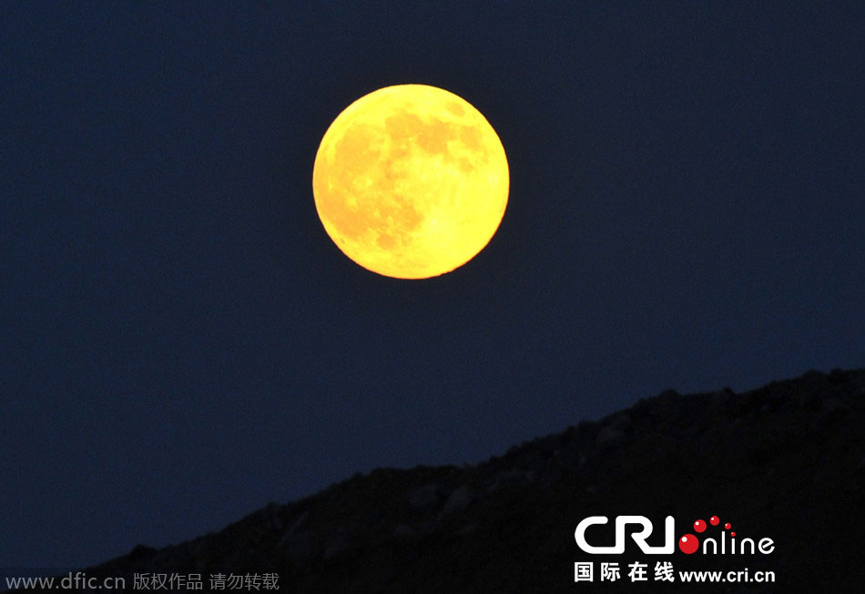 8月10日晚，一輪金燦燦的大月亮在遼寧省大連市東方升起。圖片來源：劉德斌/東方IC