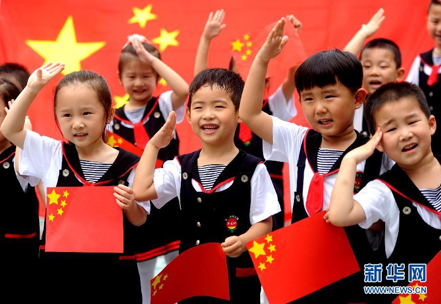  9月28日，安徽淮南市直機關(guān)幼兒園的小朋友在國旗前唱《國歌》，慶祝祖國65周歲生日。