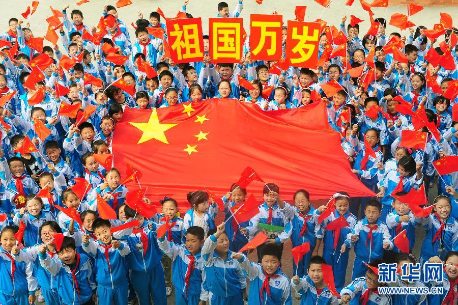 9月26日，安徽省阜陽市北城小學分校的學生與國旗合影。