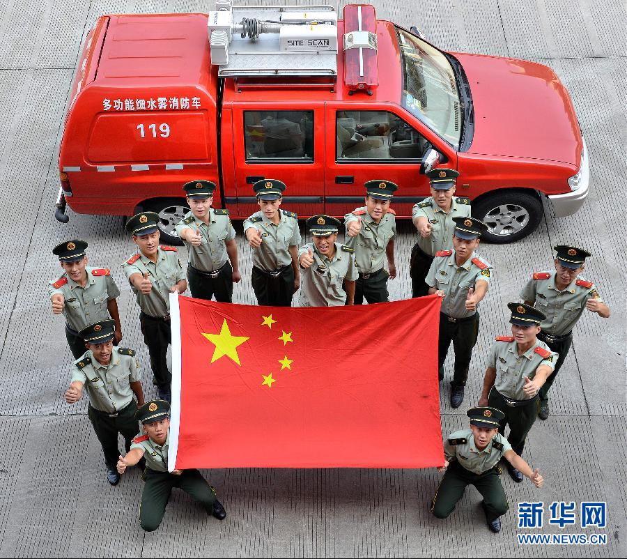  9月25日，武警浙江嘉興消防官兵與國旗合影。