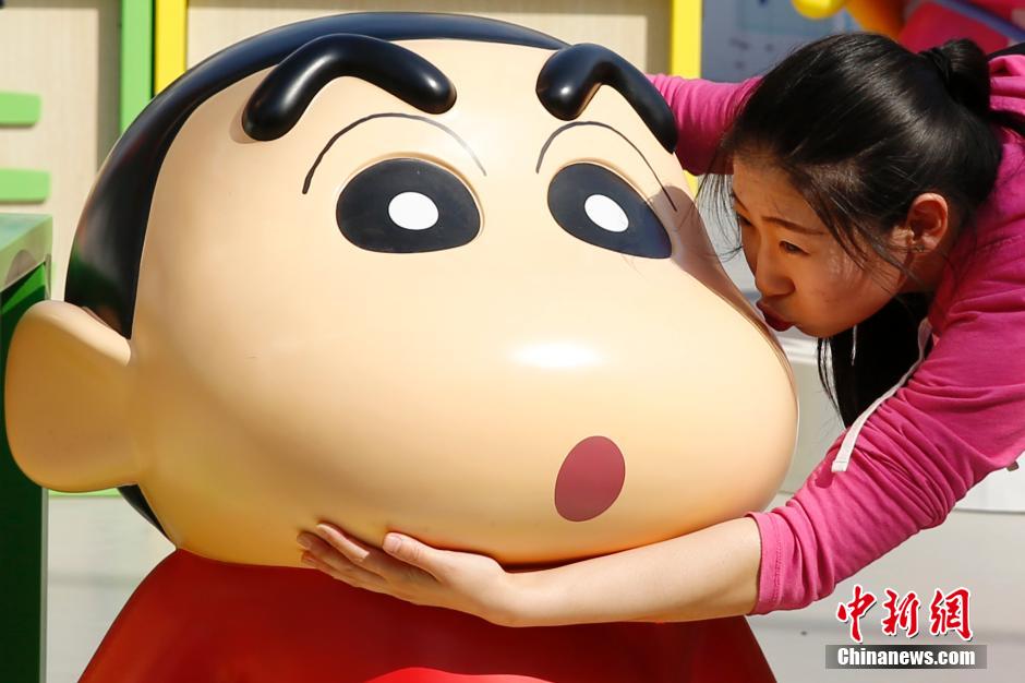 4月22日，游客與蠟筆小新合影。“蠟筆小新25周年紀(jì)念特展”日前在北京開展，吸引了不少市民游客。