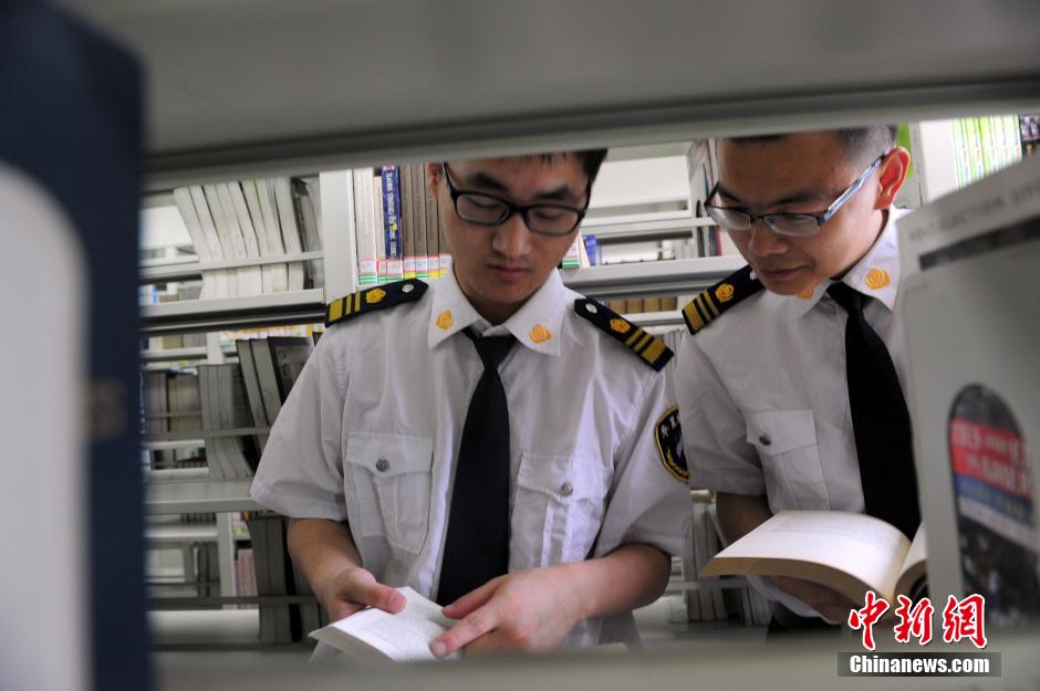 5月8日，武漢輕工大學(xué)圖書館保安吳濤與江力在圖書館交流學(xué)習(xí)。