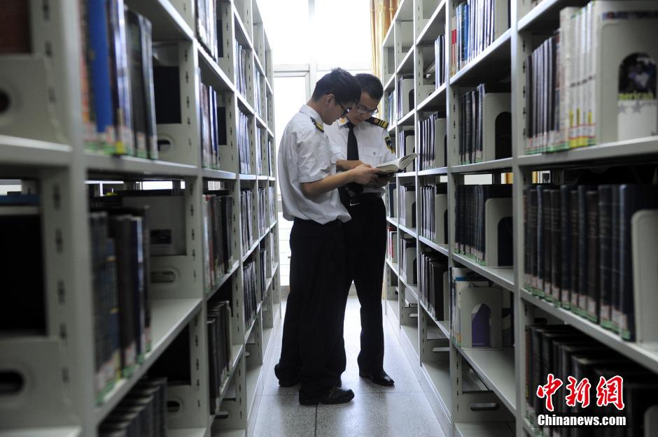 5月8日，武漢輕工大學(xué)保安吳濤與江力在圖書館交流學(xué)習(xí)。中新社發(fā) 張暢 攝