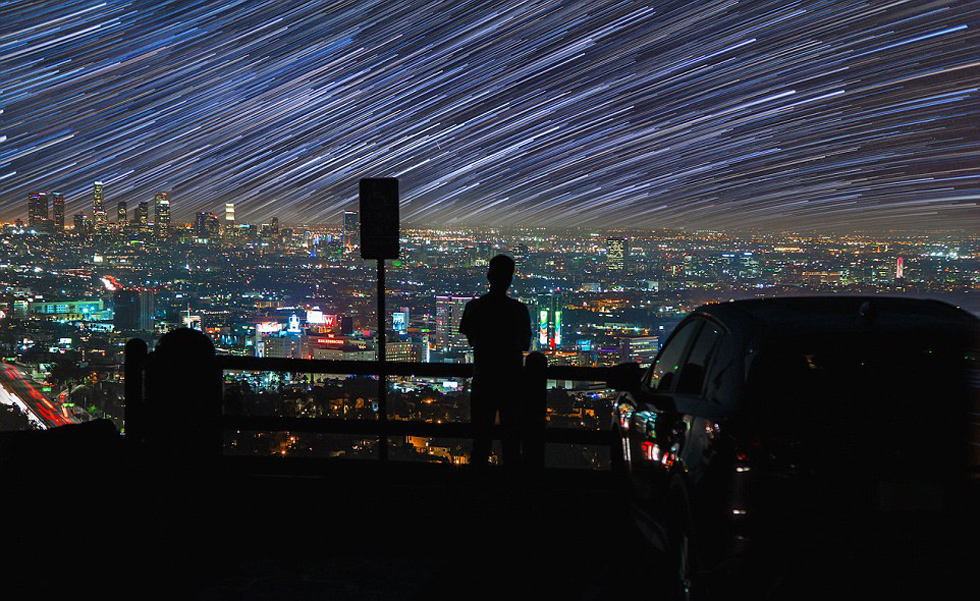 照片中，一名男子看著流星和隕星劃過天空。（網(wǎng)頁截圖）