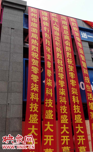 路邊一棟樓上懸掛著二三十條紅色條幅，全部是祝賀一家公司開業(yè)的。