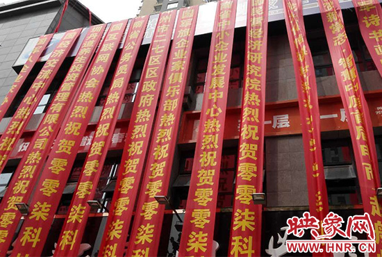 路邊一棟樓上懸掛著二三十條紅色條幅，全部是祝賀一家公司開業(yè)的。