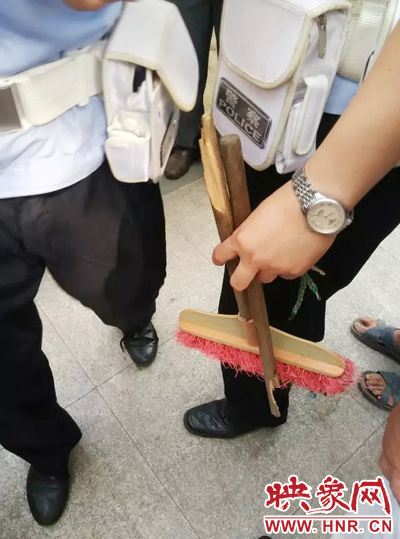 老太從環(huán)衛(wèi)工手中奪過掃帚，用腳踩斷，用力向環(huán)衛(wèi)工人的手上和腿上敲去。