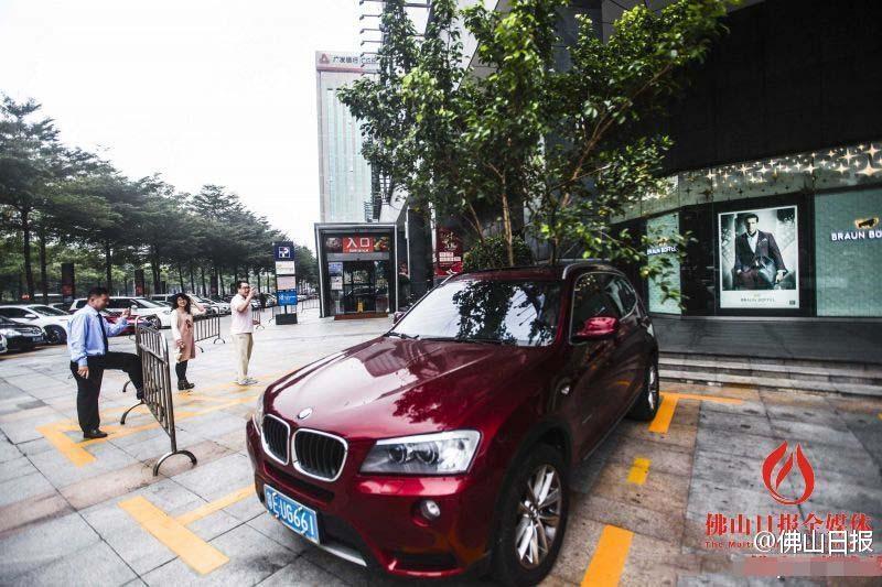 一輛停在停車位上的寶馬轎車，被墜落的樹(shù)枝砸中，樹(shù)枝徑直插入車內(nèi)，現(xiàn)場(chǎng)引發(fā)不少市民圍觀拍照。