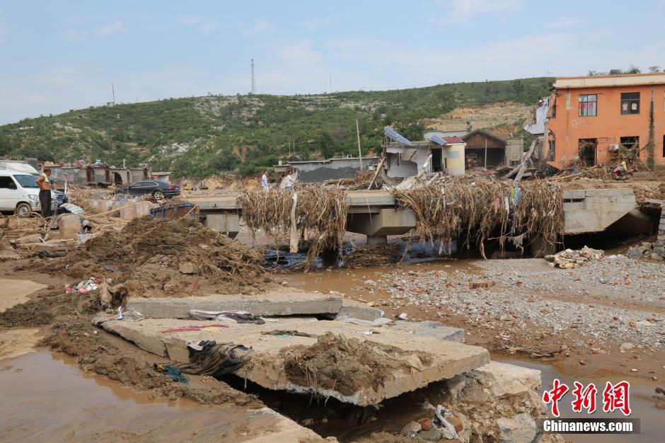 圖為洪水過后，坍塌的橋梁上遺落大量雜草。