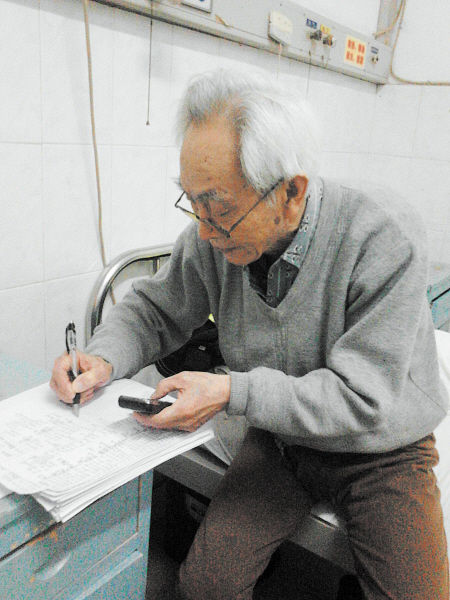 杜修源老人埋頭寫著特殊的“日記”。 李卓 攝