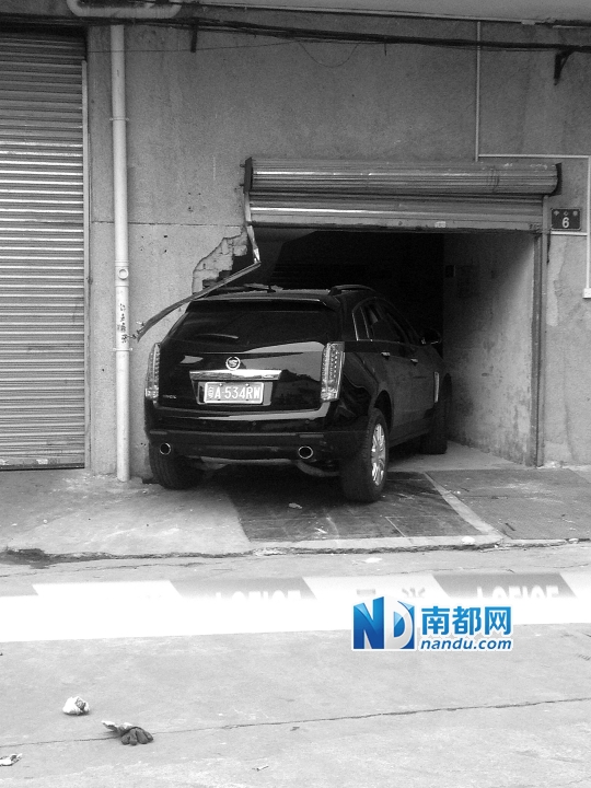 　昨日，凱迪拉克撞人后停在一倉(cāng)庫(kù)門口，車后有一攤血跡。 南都記者陳杰生攝