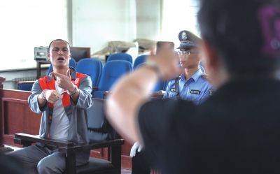 張志國在法庭上用手語回答提問。記者 蒲東峰攝