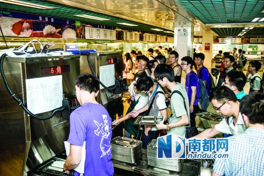 昨日，華南理工大學(xué)一食堂內(nèi)，學(xué)生們正在使用新安裝的自動(dòng)打飯機(jī)打飯。中新社發(fā)