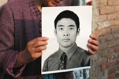 5月19日，朝陽(yáng)北路，母親捧著張東文的遺像。新京報(bào)記者 侯少卿 攝