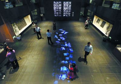 昨天，在國(guó)家典籍博物館內(nèi)，通過(guò)藝術(shù)投影技術(shù)呈現(xiàn)在展廳地面上的“漢字歷史長(zhǎng)河”，引得參觀者駐足觀看。