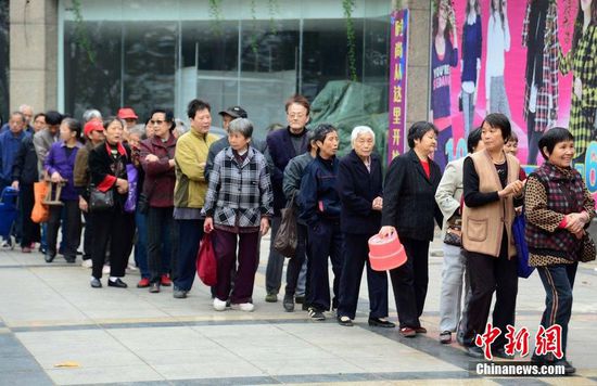 圖為10月28日，在江西九江市一家羊絨皮草服裝服飾博覽會現(xiàn)場，老人們正在頂著寒風(fēng)排隊(duì)等待領(lǐng)取10元代金劵。