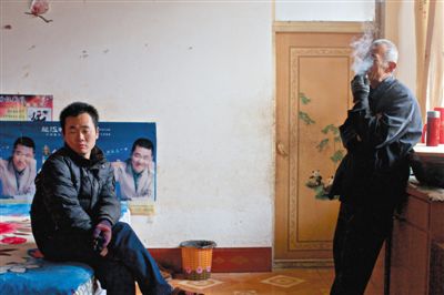 父親抽煙，兒子不語(yǔ)。逃跑的越南新娘，給袁迎賓父子帶來的是失落。新京報(bào)記者 周崗峰 攝