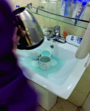 酒店服務(wù)員用潔廁液刷燒水壺和茶杯。
