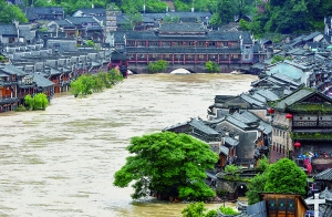 7月16日,沱江兩邊的商鋪和遠(yuǎn)處的虹橋仍淹沒在洪水中。 新華社發(fā)