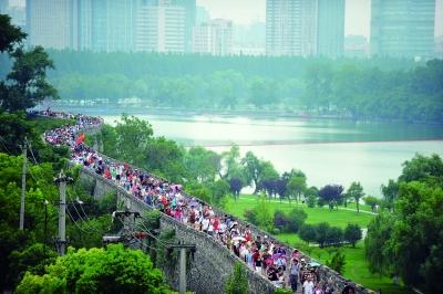 　　昨天,數(shù)萬南京市民參加“環(huán)城七十里”徒步走,圖為解放門城墻上密集的人群。 本版攝影 實習(xí)生 王甜
