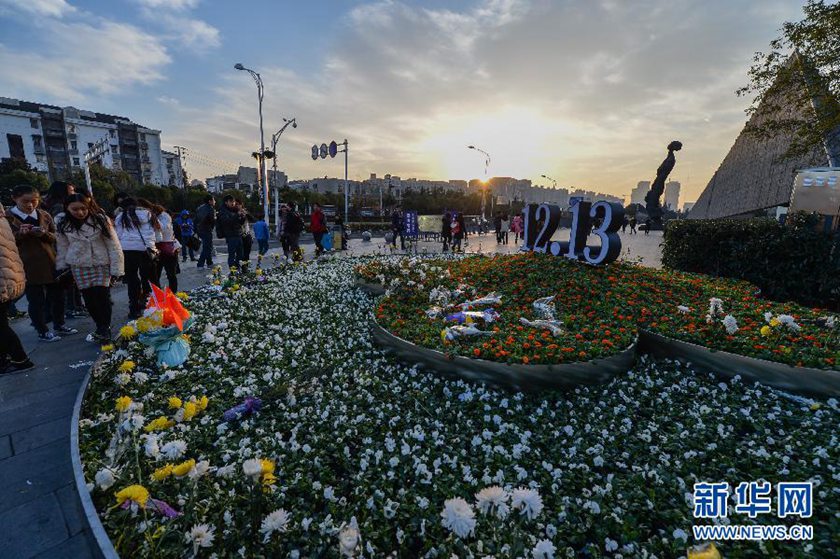12月14日,觀眾在侵華日軍南京大屠殺遇難同胞紀(jì)念館前的“12·13”花壇上擺放鮮花祭奠遇難同胞。新華社記者 沈鵬 攝