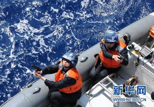 　3月28日，十余名臨檢拿捕隊員乘小艇駛至模擬可疑商船下方水面。