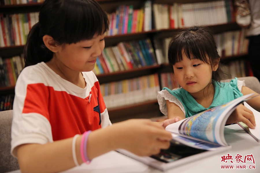 姐姐王藝茹，11歲，小學(xué)五年級學(xué)生；妹妹王有君，5歲：像喜歡看電視一樣喜歡看書。
