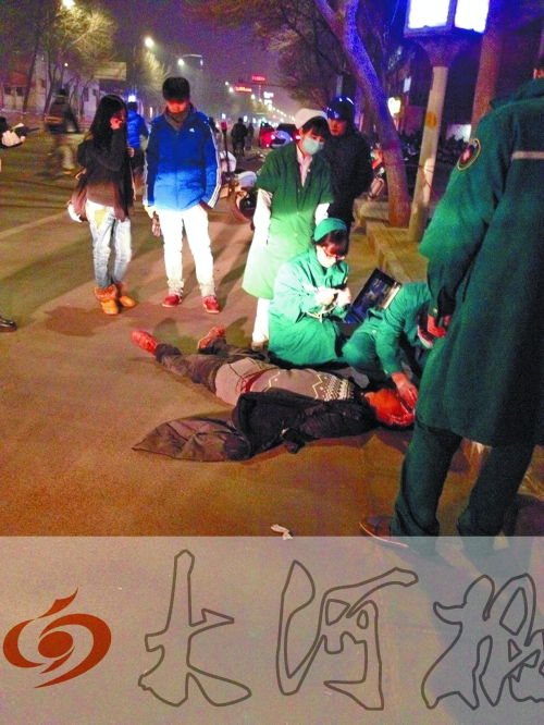醉漢躺在地上，醫(yī)護(hù)人員對(duì)其進(jìn)行檢查。